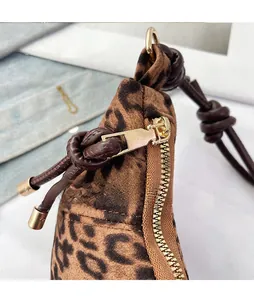 Detail of leopard print bag featuring gold metal zipper puller with brown rope knot