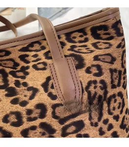 Close-up of leopard print tote bag detailing brown leather straps and fine stitching