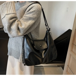 Detail of black matte PU leather hobo bag with metal chain strap and flap closure