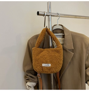 Caramel teddy fleece bucket bag detail showing adjustable PU strap and CLEAR K label