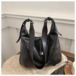 Detail of black large hobo bag featuring soft oily leather texture and silver buckle