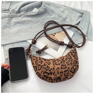 Detailed close-up of leopard print crossbody bag with knotted strap and phone for scale