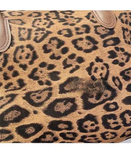 Close-up of leopard print tote bag fabric texture with premium suede and brown leather handle