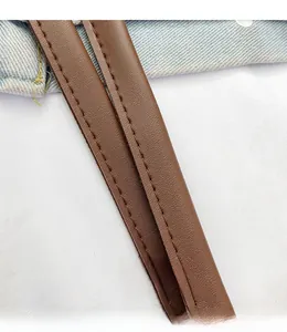 Close-up of brown faux leather tote handle featuring durable double stitching detail