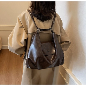 Detail view of coffee brown faux leather tote with pleated texture and silver ring hardware