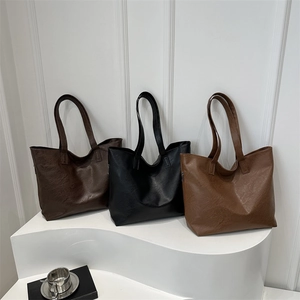 Three minimalist large capacity faux leather tote bags in dark brown, black, and light brown