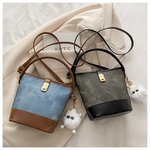 Detail of retro color-block bucket bags with gold buckle and plush monster charm