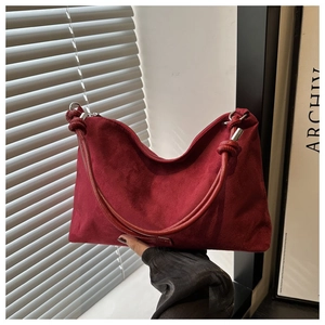 Macro detail of dark red suede hobo bag featuring a distinctive circular twisted knot handle