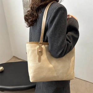 Grande borsa tote beige in finta pelle scamosciata portata a spalla con tracolla