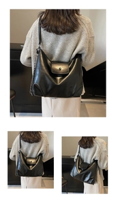 Detail of black soft leather hobo bag featuring mixed chain strap and round buckle