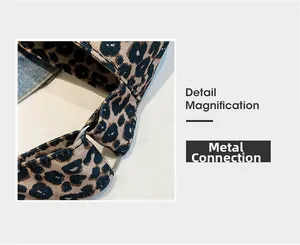 Detail view of leopard print fabric with silver metal ring and blue denim stitching