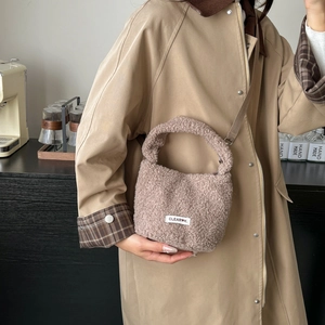Brown faux lamb wool bucket bag with CLEAR K label and adjustable crossbody strap