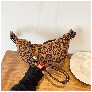 Close-up of leopard print croissant bag featuring crescent shape and knotted strap details