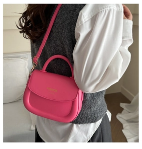 Hot pink matte leather saddle bag worn by model showing side view and fashion style