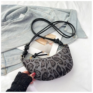 Detail of leopard print crescent bag with stylish knot straps on a white fabric background