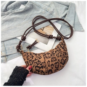 Detail of leopard print crescent bag featuring thick rope knot strap and gold hardware