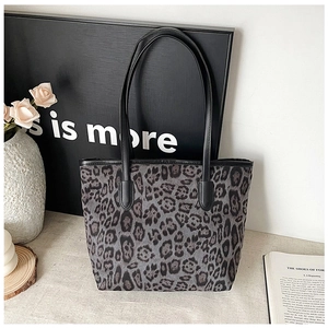 Close-up of vintage leopard print tote bag with black straps in a modern lifestyle setting