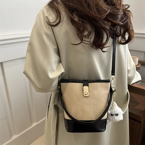 Retro contrast bucket bag in beige canvas and black leather with gold lock and plush charm