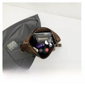 Detail view of large capacity brown leather bag showing spacious interior for tablets