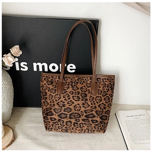 Detail of retro leopard print tote bag with brown leather straps in a lifestyle setting