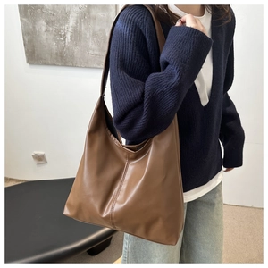 Detail of a large brown matte PU leather hobo shoulder bag with vertical stitching