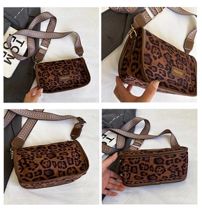Detail view of leopard print shoulder bag with wide herringbone strap and gold hardware