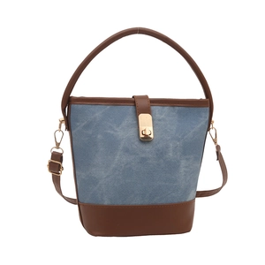 Fashionable denim bucket bag with brown leather trim and golden twist lock closure