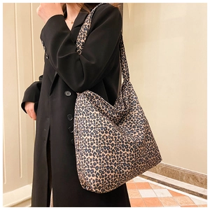 Detail of a large leopard print tote bag with soft texture and wide shoulder strap