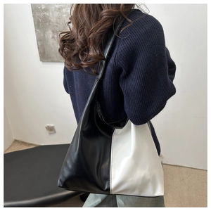 Macro view of large black and white contrast hobo shoulder bag in soft leather material