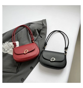 Detail of vintage high-capacity crossbody bag with gold buckle and stylish knot strap
