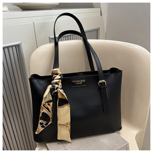 Gros plan d'un sac cabas noir en cuir avec foulard décoratif et plaque de logo élégante