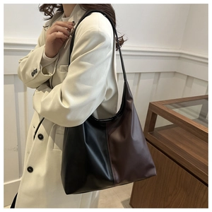 Detail of a large capacity two-tone tote bag in black and brown matte faux leather