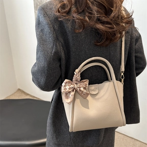 Beige litchi grain bucket bag with silk scarf on handle for women's daily commute