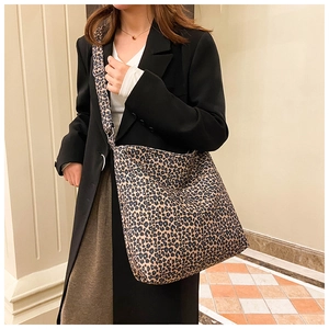 Fashionable leopard print tote bag with adjustable shoulder strap styled on a model