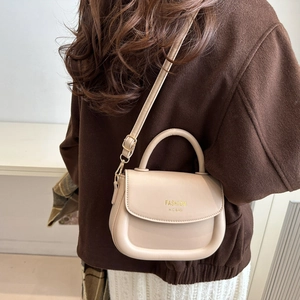 Chic beige textured crossbody bag with top handle and gold fashion lettering logo