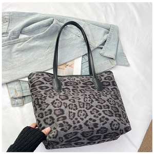 Detail shot of large leopard print tote bag with black handles and reinforced edges
