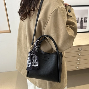 Classic black leather tote bag with silk scarf accessory and detachable shoulder strap