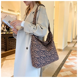 Fashionable leopard print hobo bag worn with a stylish trench coat in an urban setting