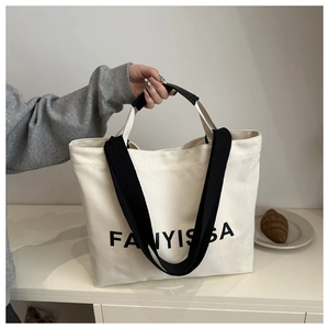 Close-up of FANYISSA canvas tote bag with dual straps and letter print detail