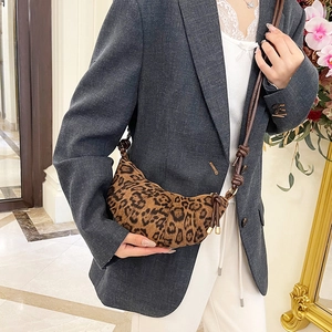 Fashionable leopard print croissant shoulder bag with unique knot strap on a model