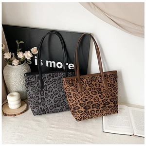 Detailed view of leopard print tote bags in gray and brown with long shoulder straps