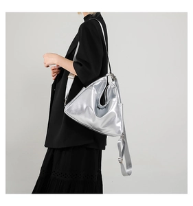 Side view of large silver metallic hobo bag with adjustable wide fabric shoulder strap