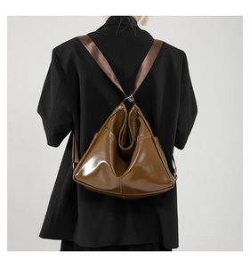 Close-up of deep brown glossy tote bag showing triangular fold and stylish texture