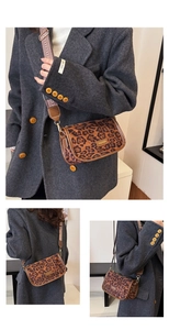 Detail of leopard print crossbody bag with wide jacquard strap and leather trim