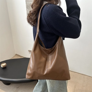 Large brown minimalist tote bag with vertical stitching shown on model for daily use