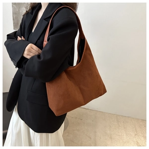 Side view of large brown suede hobo tote bag worn by model for office and daily casual style