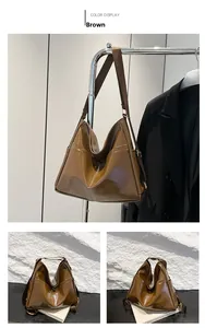 Brown soft faux leather tote bag with wide adjustable strap and side pocket detail