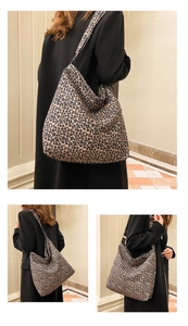 Close-up of leopard print tote bag fabric and wide shoulder strap on a hobo design