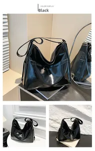 Detail of glossy black large hobo bag with reflective faux leather and wide shoulder strap