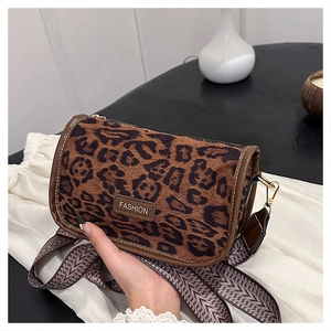 Detail of leopard print cylinder bag with woven strap and fashion metallic plaque